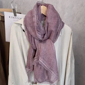 Detail of elegant dark purple linen scarf with intricate matching lace trim and soft texture