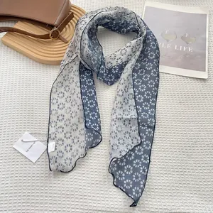 Detail of navy and white floral skinny scarf showing edge stitching and delicate fabric