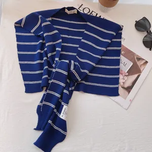 Detailed close-up of navy blue and cream striped knit shawl with high-quality fabric texture