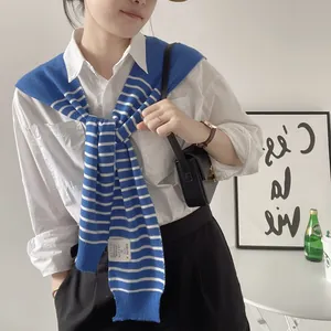 Blue and white striped knit shawl draped over a white shirt for a casual nautical look