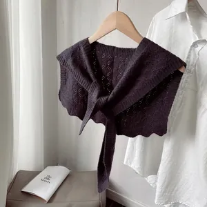 Detail of dark purple knitted hollow shawl with intricate geometric patterns and bow tie