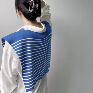 Close-up of blue and white striped knitted shawl worn over a white shirt back view