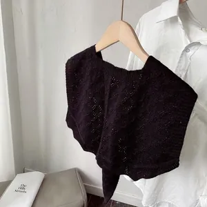 Close-up of black hollow crochet knit shawl featuring intricate diamond patterns on a shirt