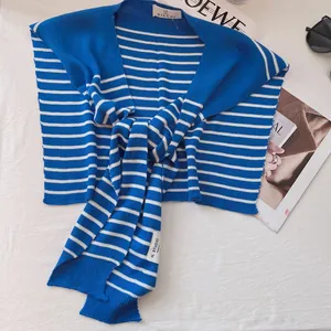 Detailed knit texture of blue and white nautical striped scarf shawl with side label