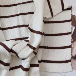 Macro detail of soft striped knit shawl texture with horizontal brown and cream patterns