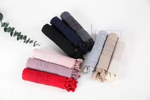 Detailed flat lay of long cotton linen scarves with lace embroidery and tassels in nine colors