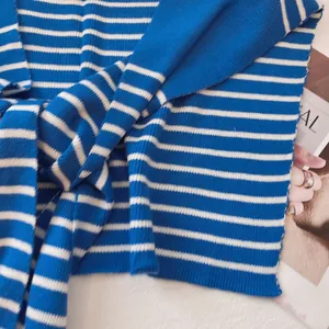 Detailed close-up of blue and white striped knit scarf showing textured ribbed pattern