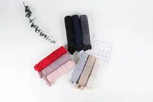 Detailed view of lightweight cotton linen scarves with lace edges and tassels in nine colors