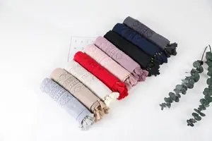 Detail view of cotton linen scarves with diamond embroidery and beaded tassels in nine colors
