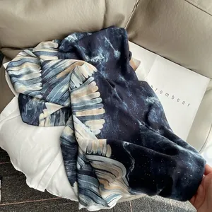 Marineblauer Schal aus Baumwollleinen mit Goldfolie und Flügelmuster auf dem Sofa