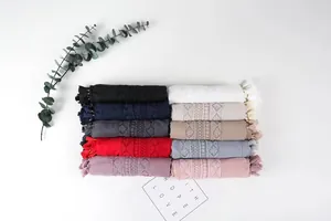 Detailed view of ten colorful cotton linen scarves with lace embroidery and beaded tassels