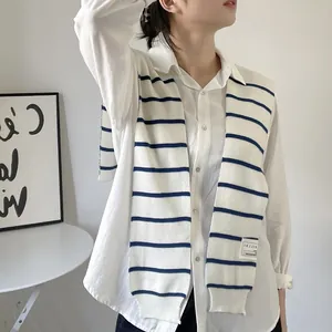 Detail of blue and white striped knit shawl layered over a white long-sleeve cotton shirt
