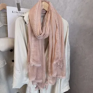 Detail of light pink linen scarf featuring delicate lace embroidery on the edges