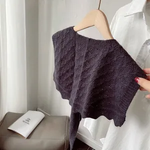 Detailed cable knit pattern on dark grey-purple knitted shawl with scalloped edges