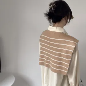 Detailed knit texture of a khaki striped shawl scarf over a beige collared shirt