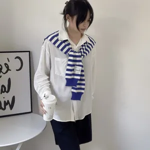 Detail of nautical blue and white striped knit shawl layered over a white shirt