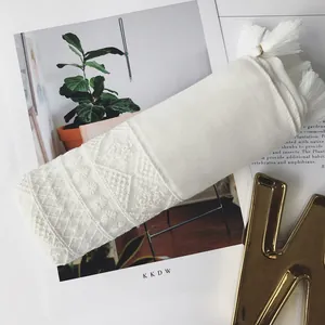 Detailed view of white cotton linen scarf with geometric lace patterns and long tassels
