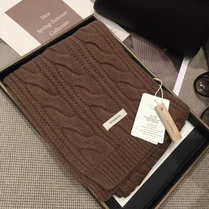 Detail of 100% wool brown cable knit scarf in premium black gift box with accessories