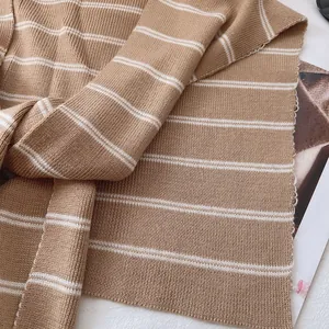 Close-up of camel striped ribbed knit shawl with soft texture and classic horizontal patterns