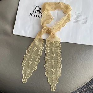 Close-up of elegant floral lace embroidery on thin summer scarf with scalloped edges