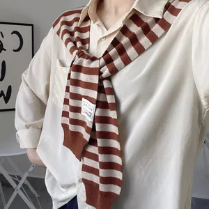 Close-up of a brown and beige striped knitted shawl over an apricot lapel blouse