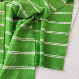 Close-up detail of soft green striped knitted fabric texture for women's shawls