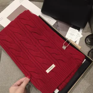 Macro detail of thick red twisted knit scarf in 100% pure wool for winter warmth