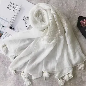 White cotton linen shawl with delicate lace patchwork and fringe tassels for beach sun protection