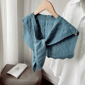 Detail of cable knit pattern and long straps on a dusty blue decorative shawl