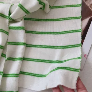 Detailed macro view of white and green striped rib knit fabric texture with soft feel
