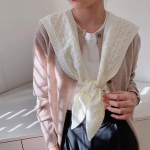 Detailed knit texture of white crochet shawl wrap with intricate cable pattern