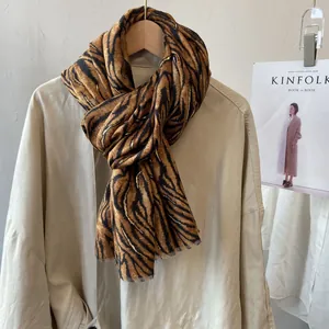 Detail of tiger print cotton linen scarf with gold thread accents and tassel edges