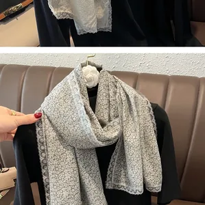 Détail d'écharpe en dentelle de coton avec imprimé floral blanc et bords en dentelle
