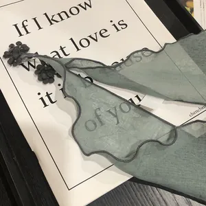 Sage green chiffon triangle scarf with wavy edges and delicate floral petal detail