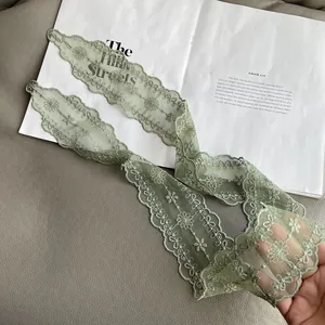 Detail of light green floral lace scarf with embroidery and wavy scalloped edges