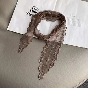 Detail of brown lace neck scarf with floral embroidery and wavy scalloped edges