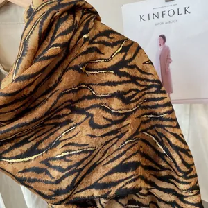 Detail of tiger print scarf featuring metallic gold foil accents and silky texture