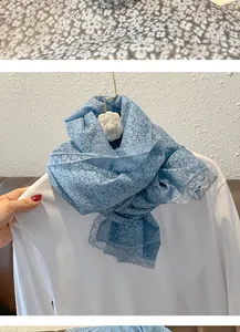 Détail d'écharpe en dentelle à fleurs bleues avec imprimés blancs et bords délicats
