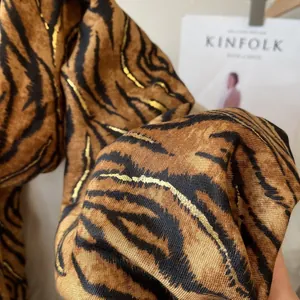 Macro shot of gold-stamped tiger stripe pattern on smooth cotton-linen fabric texture