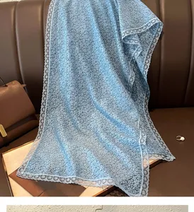 Détail d'une écharpe bleu clair à fleurs avec bordure en dentelle blanche raffinée