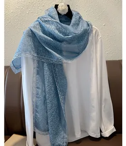 Détail de l'écharpe bleue à fleurs avec bordure en dentelle délicate et tissu léger en lin