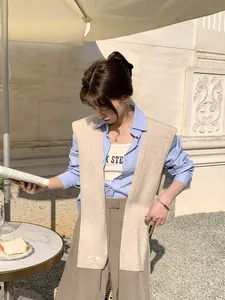 Dettaglio dello scialle in lana premium sopra camicia blu e pantaloni a gamba larga