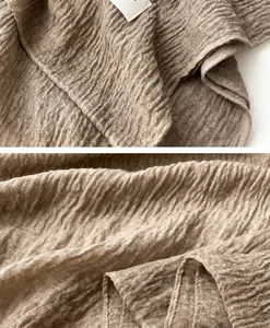 Macro shot of khaki pleated cotton-linen scarf fabric with textured edge details