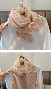 Détail d'une écharpe rose à fleurs avec une fine bordure en dentelle de cils