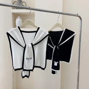 Detail of knit shawl wrap set in black and white with contrast trim and ties