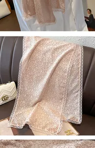 Détail d'un châle en mousseline avec imprimé floral et bordure en dentelle blanche