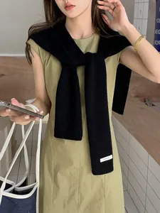 Dettaglio dello scialle in maglia 100% lana australiana con trama nera ed etichetta