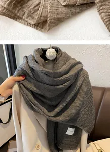 Detailed view of dark grey pleated cotton linen scarf with texture and woven brand label