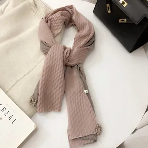 Detail of pink and grey linen scarf with pleated texture and 3D floral pendant