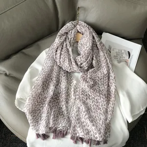Bohemian silk shawl with golden wheat pattern and purple tassels over white shirt